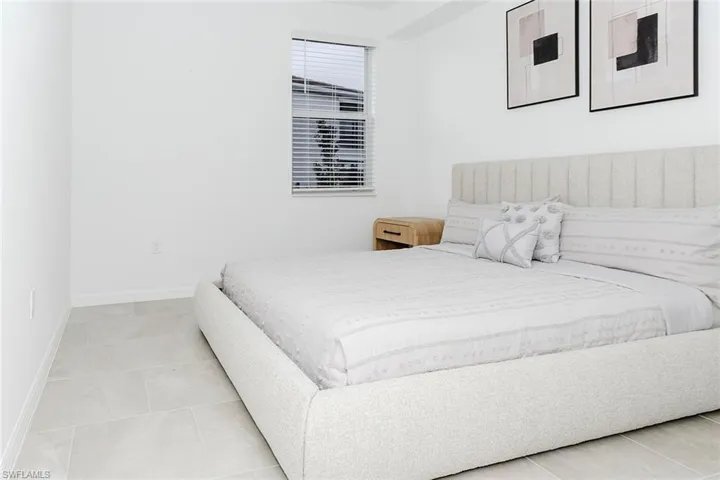 Bedroom with baseboards and light tile patterned flooring