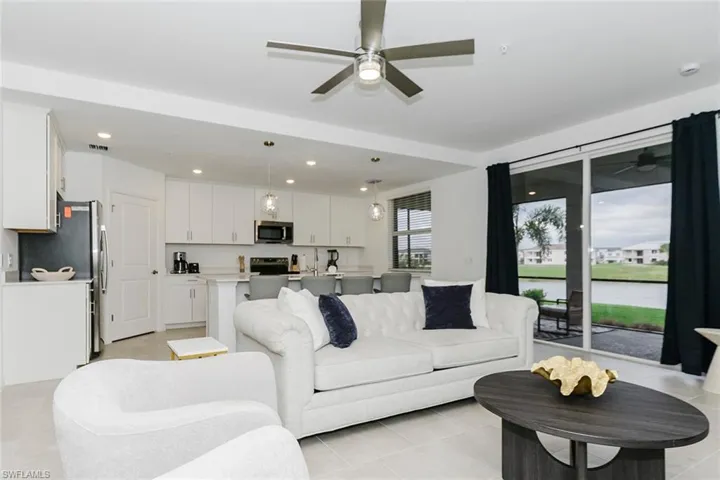 Living room with ceiling fan, recessed lighting, and light tile patterned floors