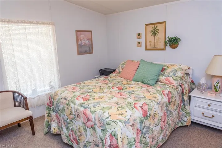 Bedroom with dark colored carpet and crown molding