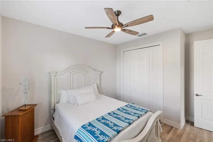 Bedroom with light hardwood / wood-style floors, a closet, and ceiling fan