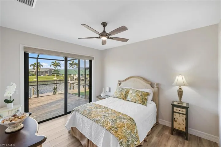 Bedroom featuring access to exterior, hardwood / wood-style floors, and ceiling fan