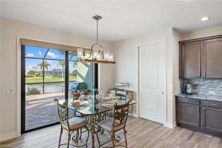 Dining room featuring a water view, an inviting chandelier, and light hardwood / wood-style floors