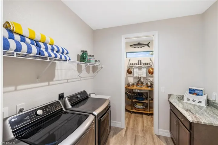 Laundry area featuring washer and dryer, light hardwood / wood-style floors, and cabinets