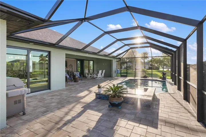 View of pool with glass enclosure and a patio area