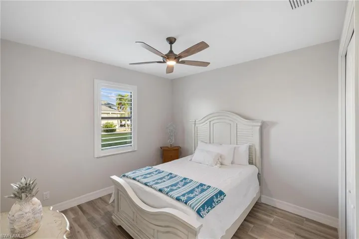Bedroom with ceiling fan, a closet, and light hardwood / wood-style flooring