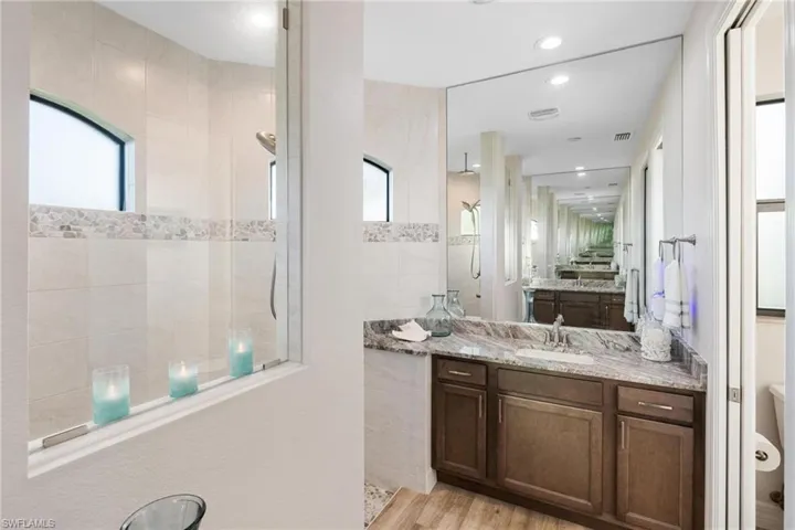 Bathroom featuring a shower, hardwood / wood-style floors, and vanity