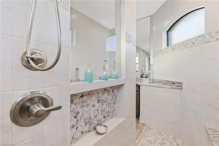 Bathroom featuring a tile shower and tile walls