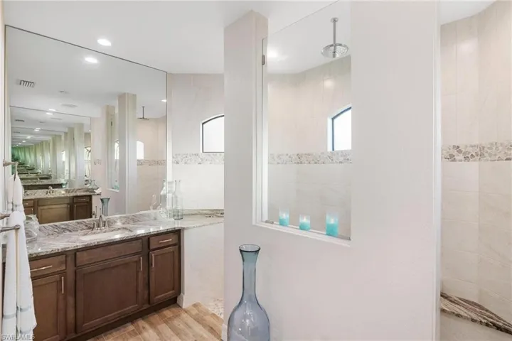 Bathroom with a tile shower, vanity, and hardwood / wood-style flooring
