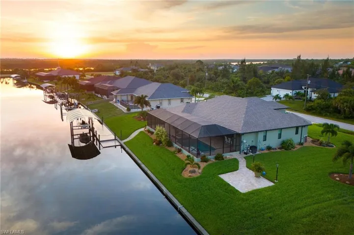 Aerial view at dusk featuring a water view