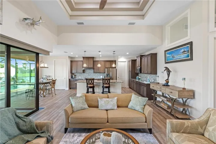 Living room featuring a raised ceiling and light hardwood / wood-style flooring