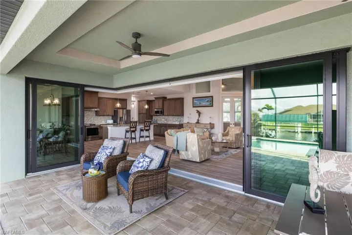 Living room with light hardwood / wood-style flooring and ceiling fan with notable chandelier