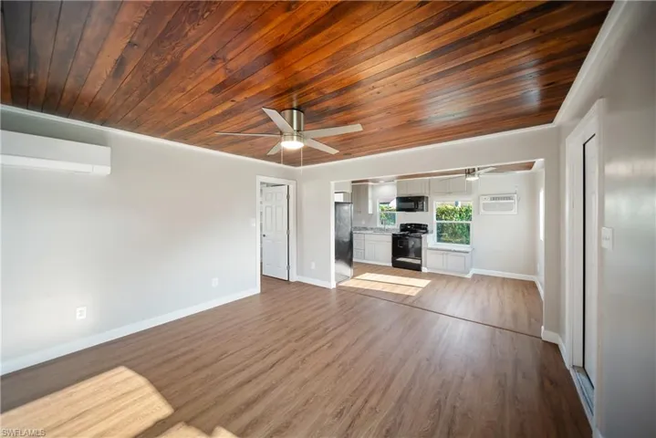 Living room wood ceiling, ceiling fan, baseboards, and wood finished floors