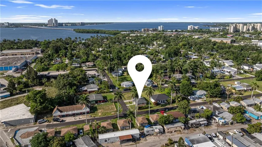 Aerial view of property's location featuring a large body of water and nearby urban area