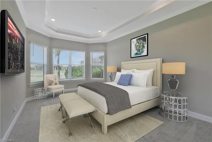 Carpeted bedroom with a tray ceiling, ornamental molding, recessed lighting, and baseboards