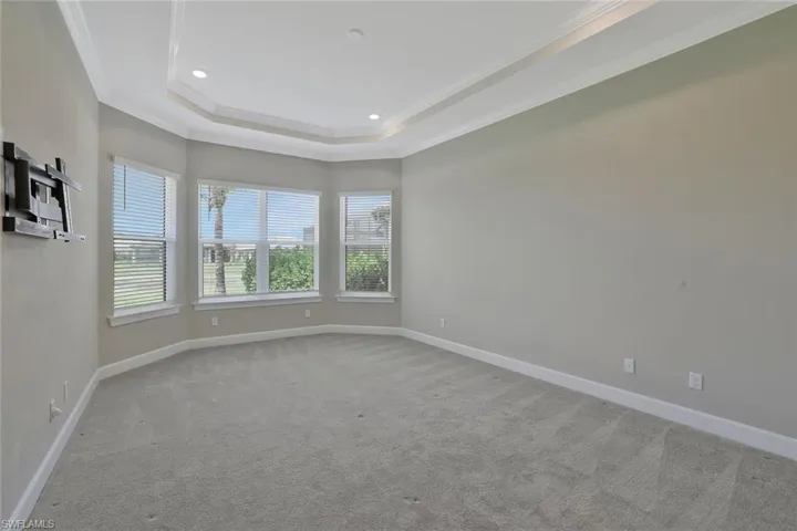 Unfurnished room with recessed lighting, carpet, a tray ceiling, crown molding, and baseboards