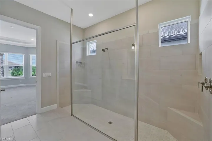 Full bathroom with tile patterned flooring, a walk in shower, and a healthy amount of sunlight