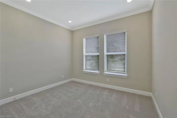 Empty room featuring recessed lighting, crown molding, baseboards, and light carpet
