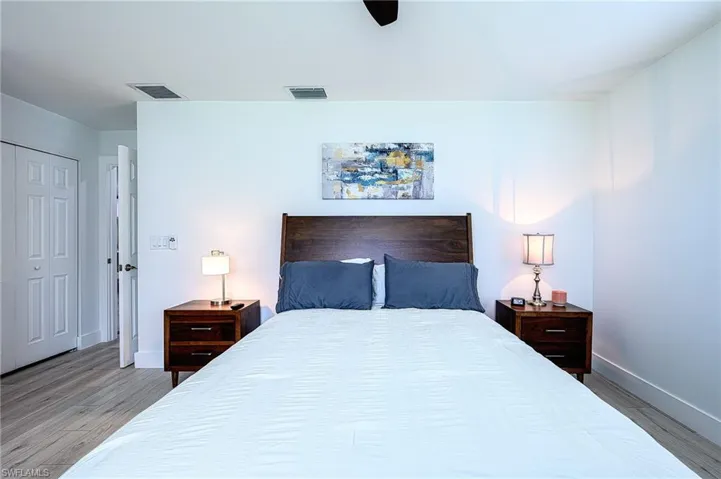 Bedroom with ceiling fan, a closet, and wood-type flooring