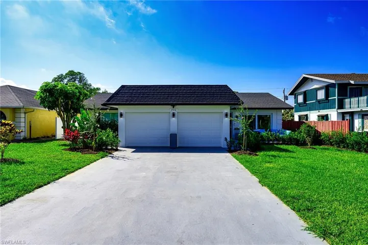 View of front facade featuring a  2 car garage and a front lawn