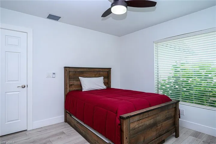 large 3rd Bedroom with ceiling fan and light hardwood / wood-style floors and  2 beds
