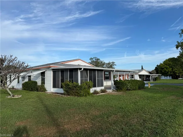 View of front of house featuring a front yard, a carport, and a sunroom