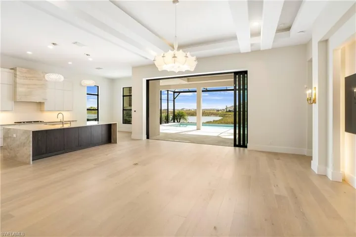 Unfurnished dining area with a chandelier, recessed lighting, light wood-style floors, and beam ceiling