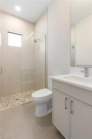 Bathroom with a stall shower, vanity, and light tile patterned floors
