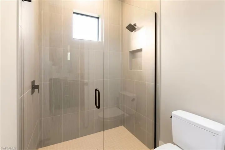 Full bath with toilet and a shower stall
