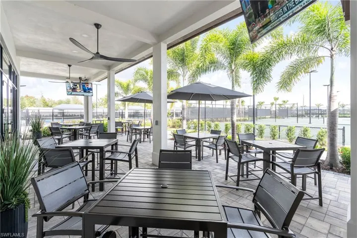 View of patio with outdoor dining area and ceiling fan