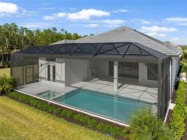 Rear view of property featuring a lanai, a sunroom, a yard, and a patio