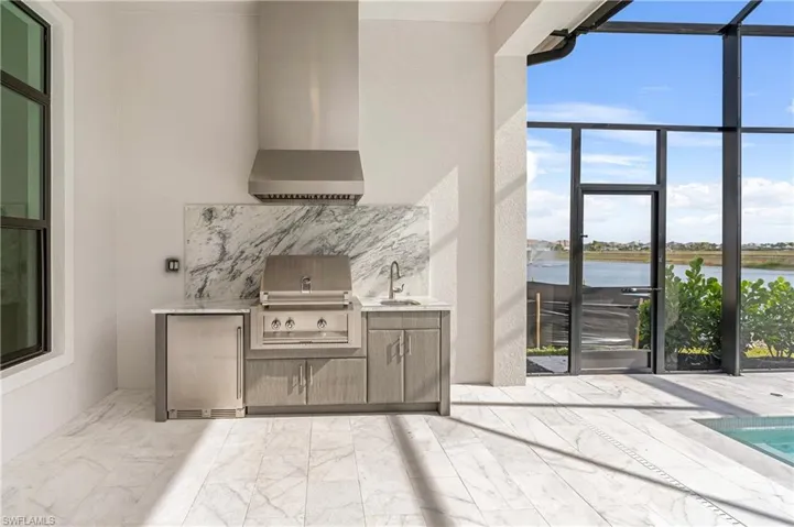 View of patio featuring a sunroom, glass enclosure, area for grilling, and a water view