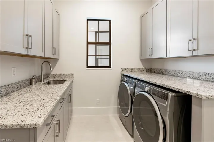Laundry room featuring washing machine and clothes dryer and cabinet space
