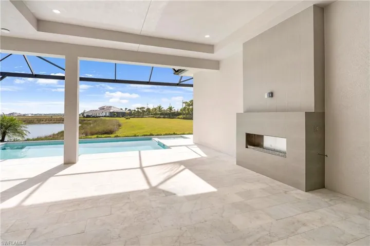 Swimming pool with a patio, glass enclosure, and exterior fireplace