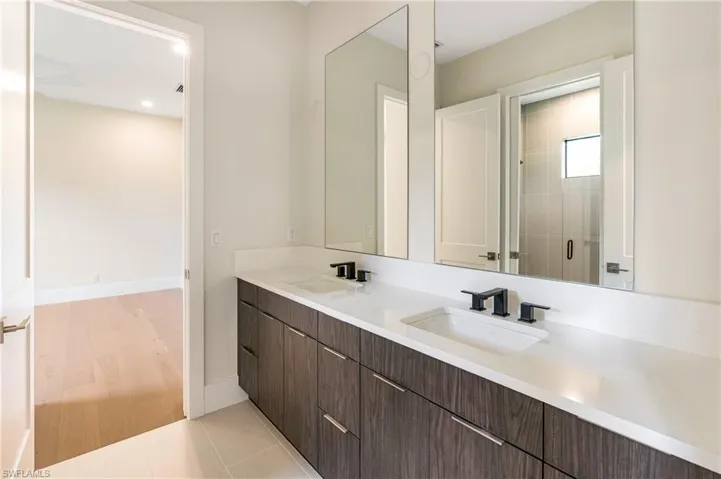 Full bathroom with double vanity, a stall shower, light tile patterned floors, and recessed lighting