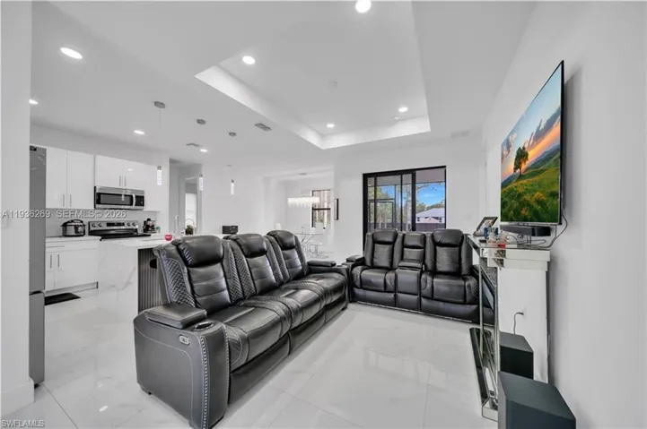 Living room with recessed lighting and a raised ceiling