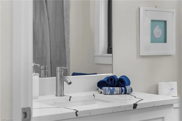 Bathroom vanity featuring a single basin sink and a contemporary brushed nickel faucet