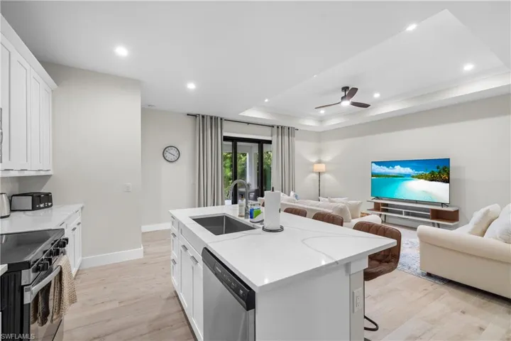 Spacious open-concept living area featuring wood-finish flooring and a kitchen island with seating