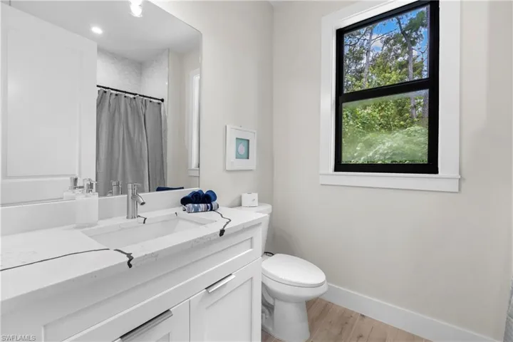 Bathroom vanity featuring an integrated rectangular sink, chrome faucet, and white cabinetry