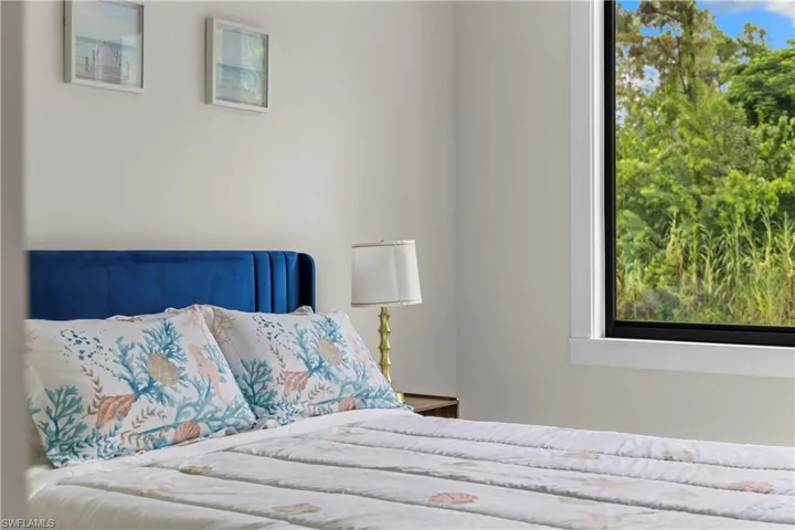 Bright room featuring a large window with white trim, offering expansive views of lush greenery