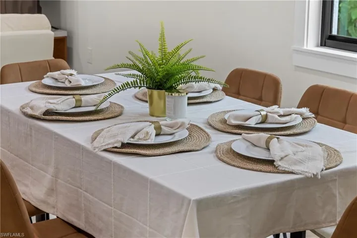 Dining area featuring a table with a light-colored tablecloth and upholstered chairs