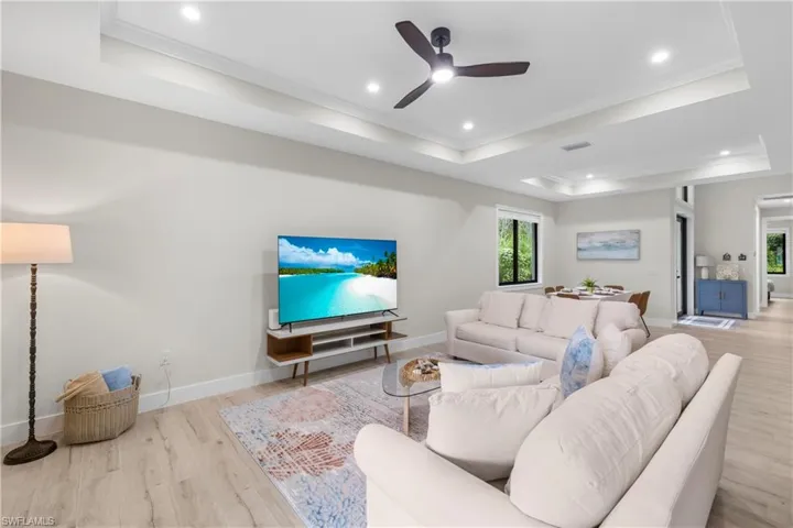 Expansive living area featuring light wood-finish flooring, recessed lighting, and a contemporary ceiling fan
