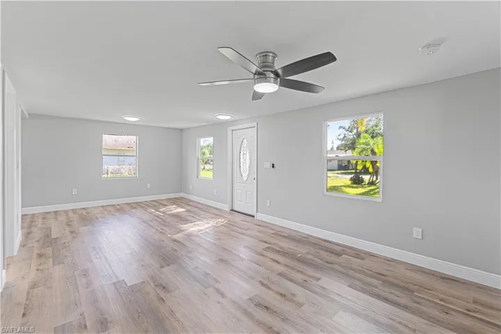 Empty room with light wood-type flooring, plenty of natural light, and ceiling fan