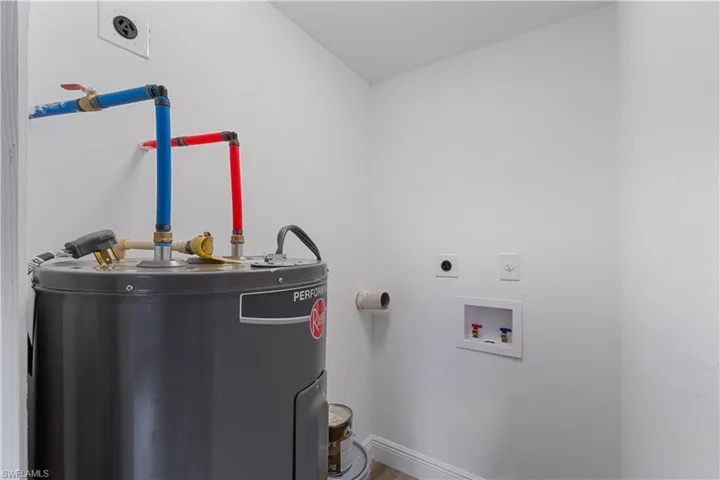 Clothes washing area featuring washer hookup, electric water heater, and electric dryer hookup
