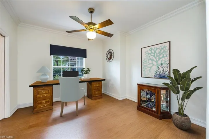 Office with baseboards, a ceiling fan, wood finished floors, and crown molding