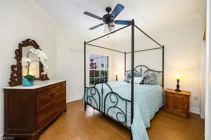 Bedroom with light wood finished floors, ceiling fan, baseboards, and ornamental molding