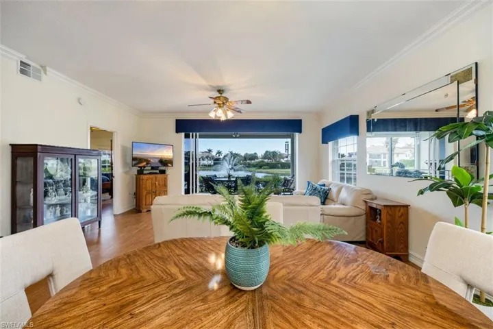 Dining space with visible vents, ornamental molding, wood finished floors, baseboards, and ceiling fan