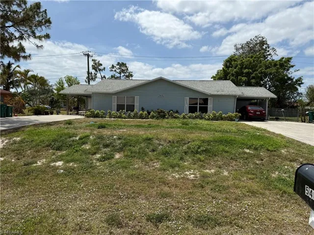 Ranch-style house with a front lawn, driveway, and an attached carport