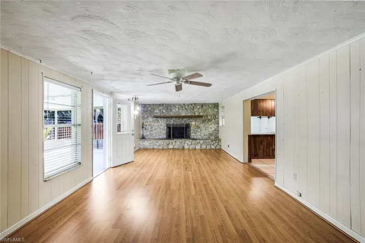 Large family room with wood-burning, stone-surround fireplace