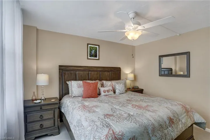 Tiled bedroom featuring ceiling fan