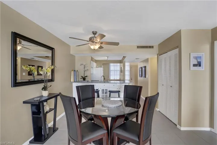 Tiled dining space featuring sink and ceiling fan